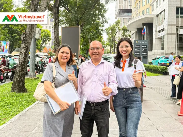 Chuyên viên Vietmytravel cùng khách hàng cầm hồ sơ visa