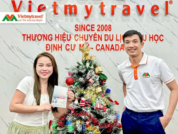 Khách hàng cầm hộ chiếu có visa Mỹ cùng chuyên viên Vietmytravel