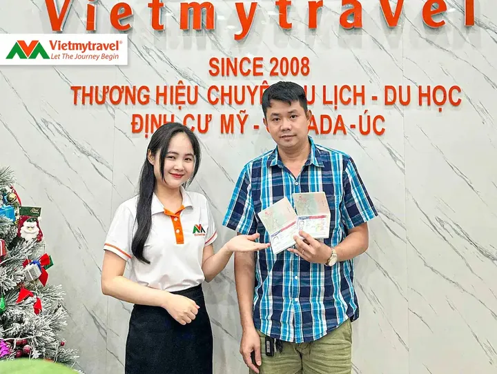 Khách hàng cầm hai hộ chiếu có visa Mỹ cùng chuyên viên Vietmytravel